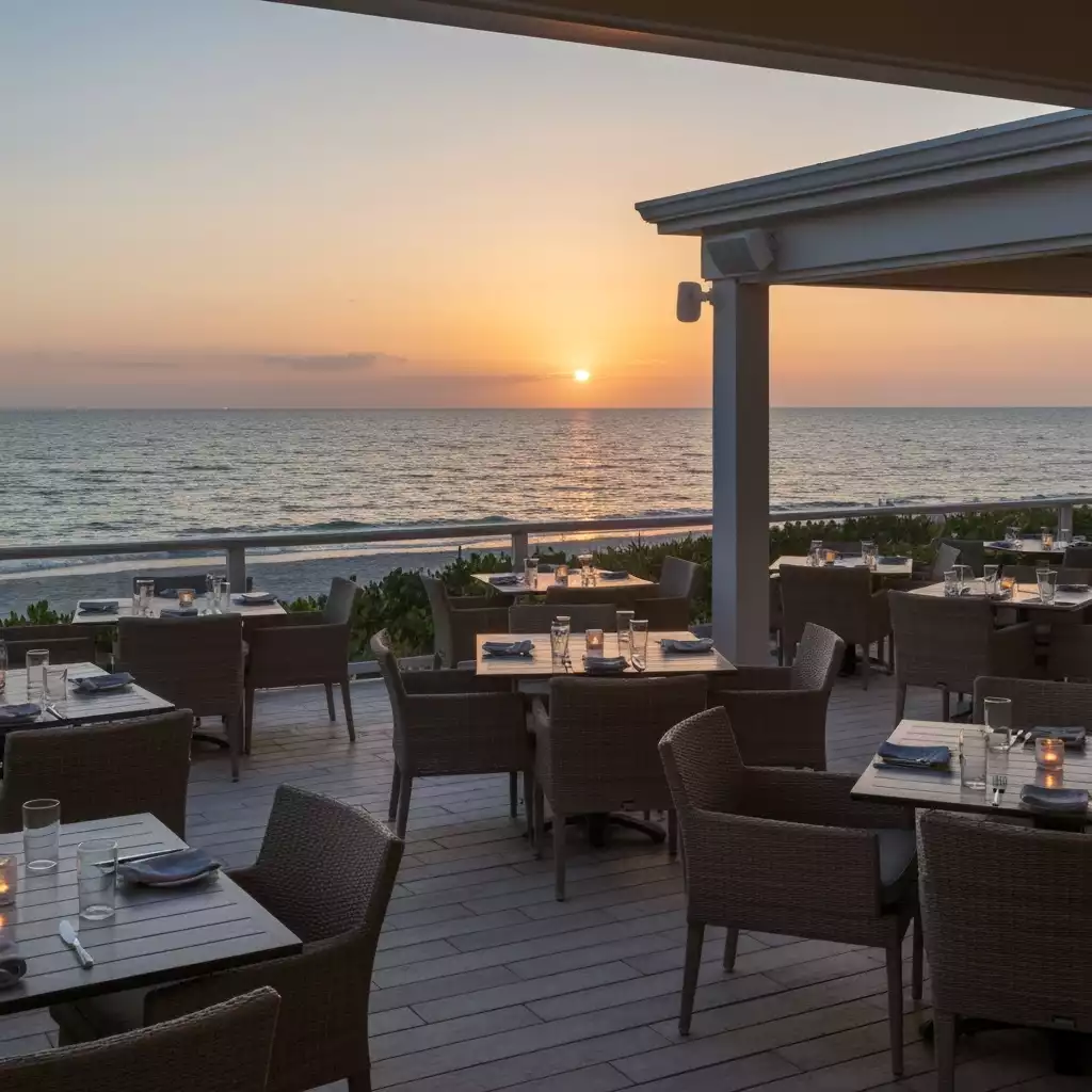 Outdoor dining area overlooking the ocean at sunset